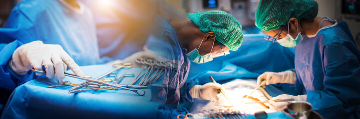 Team of doctors or surgeons in hospital surgery operating emergency room showing patient heart...