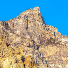 Square Precipitous slope of a rocky mountain gainst clear blue sky in Provo Canyon