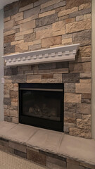 Vertical Modern fireplace and decorative shelf against stone brick accent wall of home
