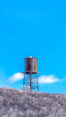 Vertical crop Cylindrical water storage tank container on a steel tower at Wasatch Mountains