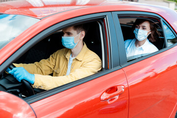 Fototapeta na wymiar male driver and woman in medical masks and gloves in taxi during covid-19 pandemic