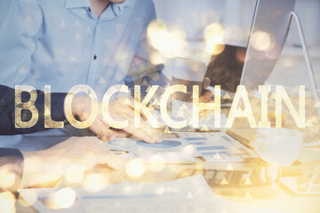 Crypto currency theme hologram with businessman working on computer on background. Concept of blockchain. Multi exposure.