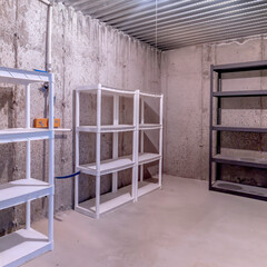 Square crop Empty multi layer metal racks inside a storage room with concrete wall and floor
