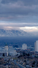 Vertical Downtown Salt Lake City with amazing view of steep snowy mountain in winter