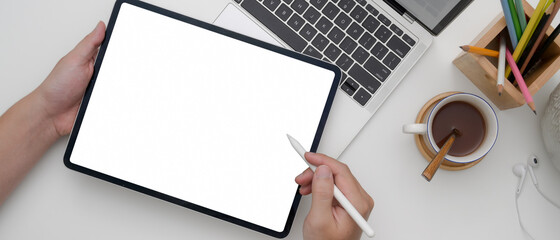 Female entrepreneur using blank screen tablet while working with laptop on white office desk