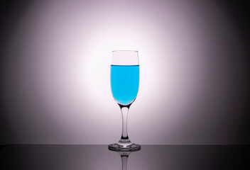 glass glasses with blue wine on a beautiful gradient background