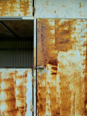 錆びた鉄板の戸のある物置き小屋
