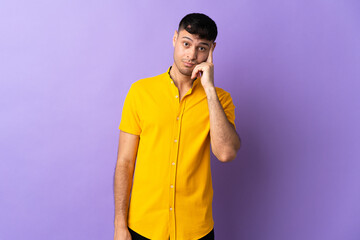 Young Colombian man isolated on purple background thinking an idea