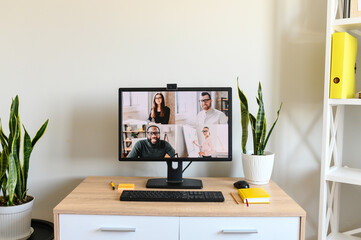 No people in the office. PC display with video meeting on it