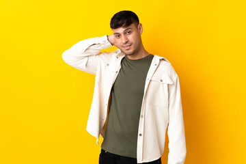 Young Colombian man isolated on yellow background laughing
