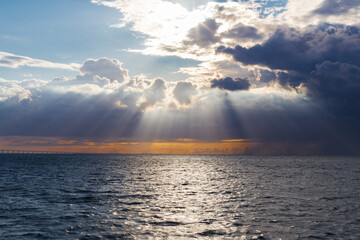 Sun rays break through clouds and illuminate the ocean, evening sunset, south africa