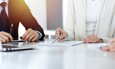 Business people discussing contract while working together in sunny modern office. Unknown...