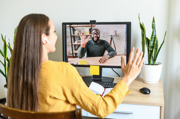Remote work. A young woman has video meeting with an african-american coworker, employee. She...