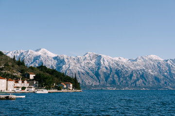 Fototapeta na wymiar The city of Perast against the backdrop of snow-capped mountains.