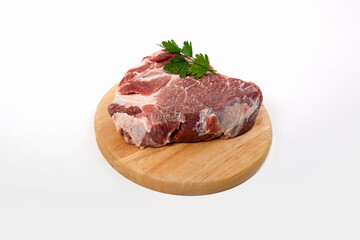 a piece of raw meat pork on a wooden backing