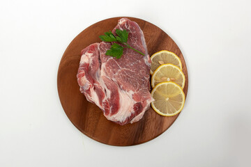 a piece of raw meat pork on a wooden backing