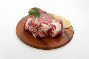 a piece of raw meat pork on a wooden backing