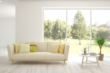 White living room with sofa and summer landscape in window. Scandinavian interior design. 3D illustration