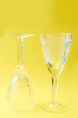 two crystal wine glasses on a yellow background