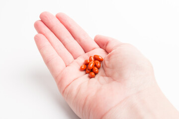 Coenzyme q10 supplement capsules in hand close-up on  white background