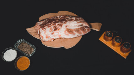 Sliced meat on a black background. Marinated pork with spices close up before cooking kebabs.