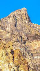 Fototapeta na wymiar Vertical Precipitous slope of a rocky mountain gainst clear blue sky in Provo Canyon