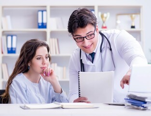 Female patient visiting male doctor for regular check-up in hosp