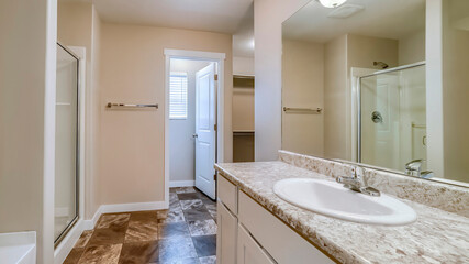 Panorama Sink and mirror in front of bathtub and shower stall inside tile floor bathroom