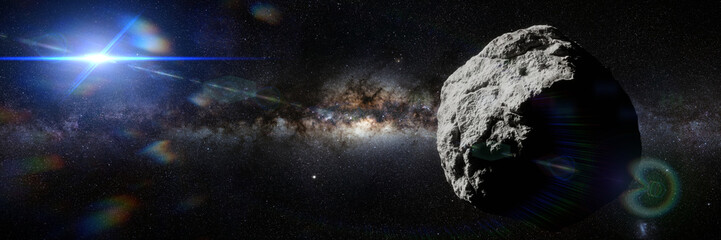 Fototapeta na wymiar asteroid in empty space lit by the Sun, banner format background 