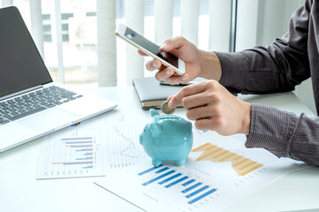 businessman are putting coins in the piggy bank Saving money with coins Step into a business that is growing to be successful and save for retirement ideas