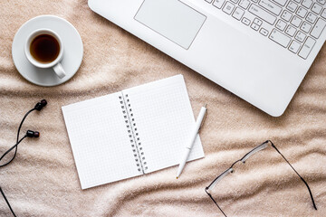 workplace at home - laptop on a bed, top view