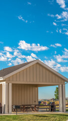Vertical frame Building with attached picnic pavilion at a park against mountain and blue sky