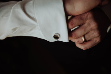 groom wears cufflinks on his shirt