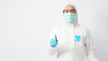 Male model with PPE suite and Hand wearing doctor glove is holding blood test tube on white background.