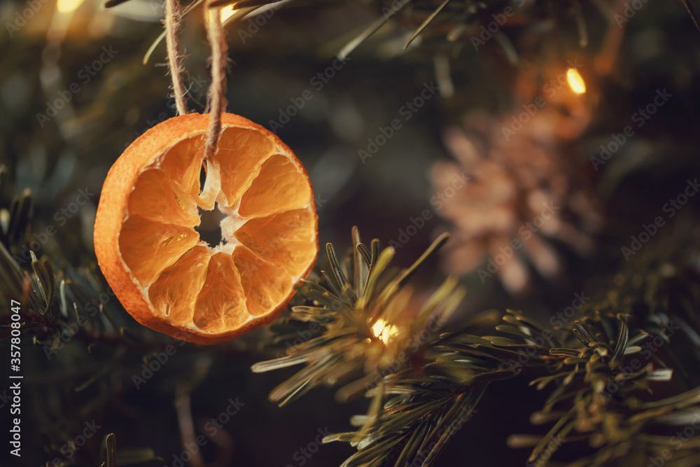 Wall mural Zero waste christmas concept. Christmas tree decorated with ornaments made of natural materials - slices of dried orange and cones