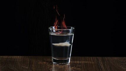 The bartender fire to an alcoholic cocktail with sambuca and Irish cream