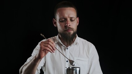 Bartender putting sugar powder in shaker while preparing alcoholic cocktail