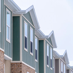 Square Vertical siding and stone brick wall at the townhomes upper storey against sky