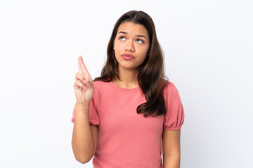 Young Colombian girl over isolated white background with fingers crossing and wishing the best