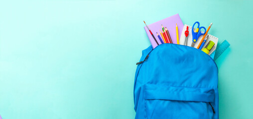School bag. Backpack with supplies for school on green background. Copy space for text
