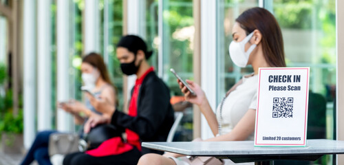 Close up of  label with text 'check in please scan' and QR code for customer to check in before enter a restaurant, application for covid-19 situation quarantine