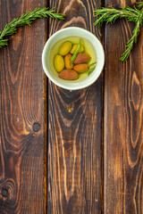 Mixed olives in bowl and rosemary branches top view space for text