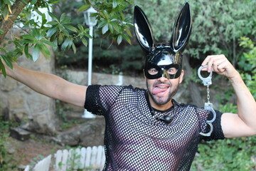 Attractive man wearing bunny mask holding handcuffs