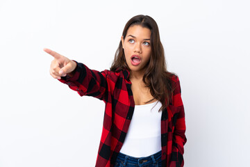 Young Colombian girl over isolated white background pointing away