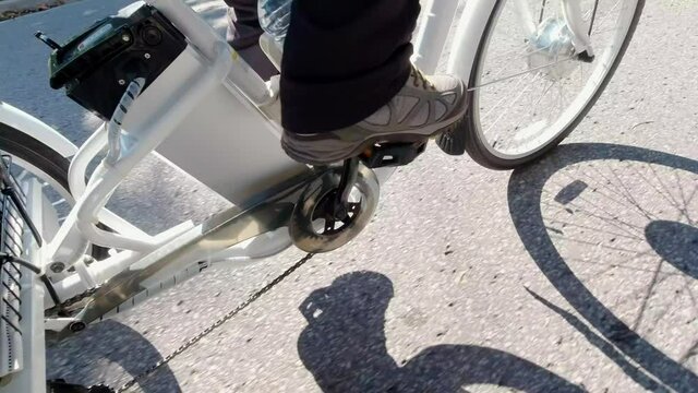 Cyclist riding an electric bicycle in the urban city area. Ecology concept. Shot from the side.