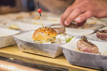Presentation of small hamburgers stuffed with cheese and sauces in a restaurant.