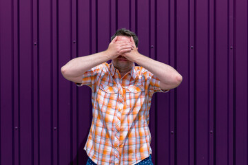 Fototapeta premium Man covers his face with his hands.Grape Compote outdoor background