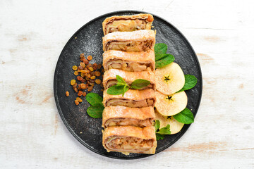 Sweet Strudel with apples and dried fruits. Top view, free copy space.