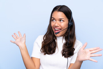 Young telemarketer Colombian woman over isolated blue background with surprise facial expression