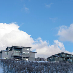 Square Blue sky and puffy clouds over homes on an inceredible mountain setting in winter